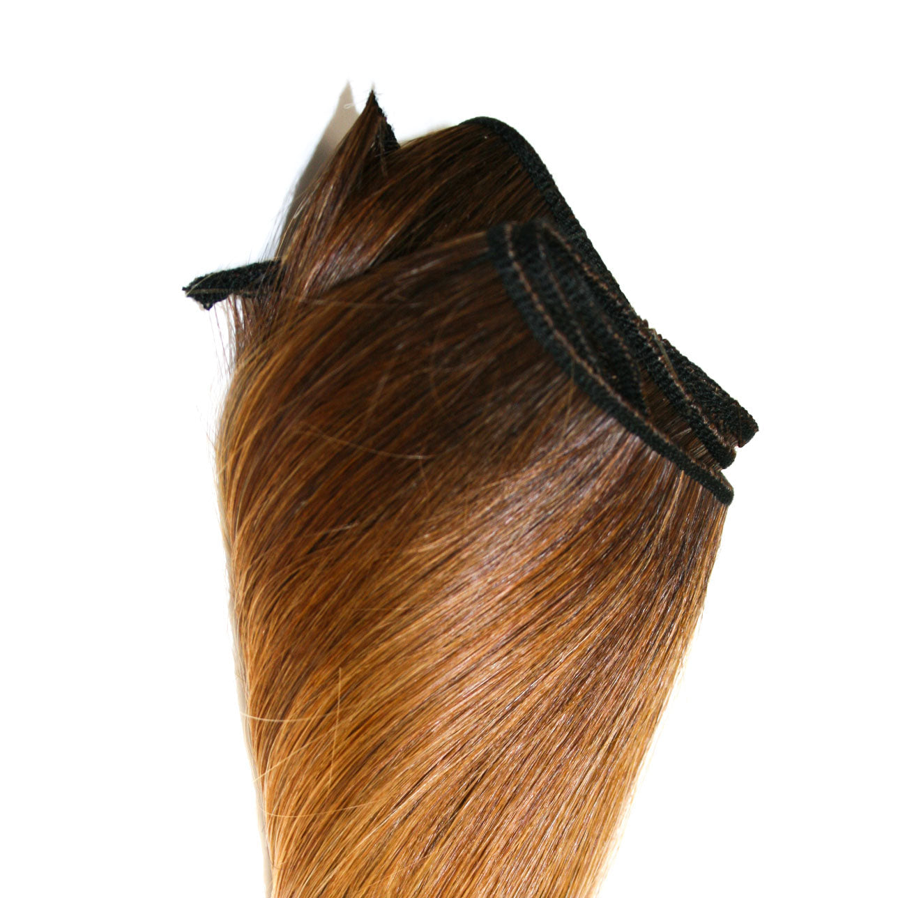Wefted human hair extensions. Medium blonde hair with dark hair roots.