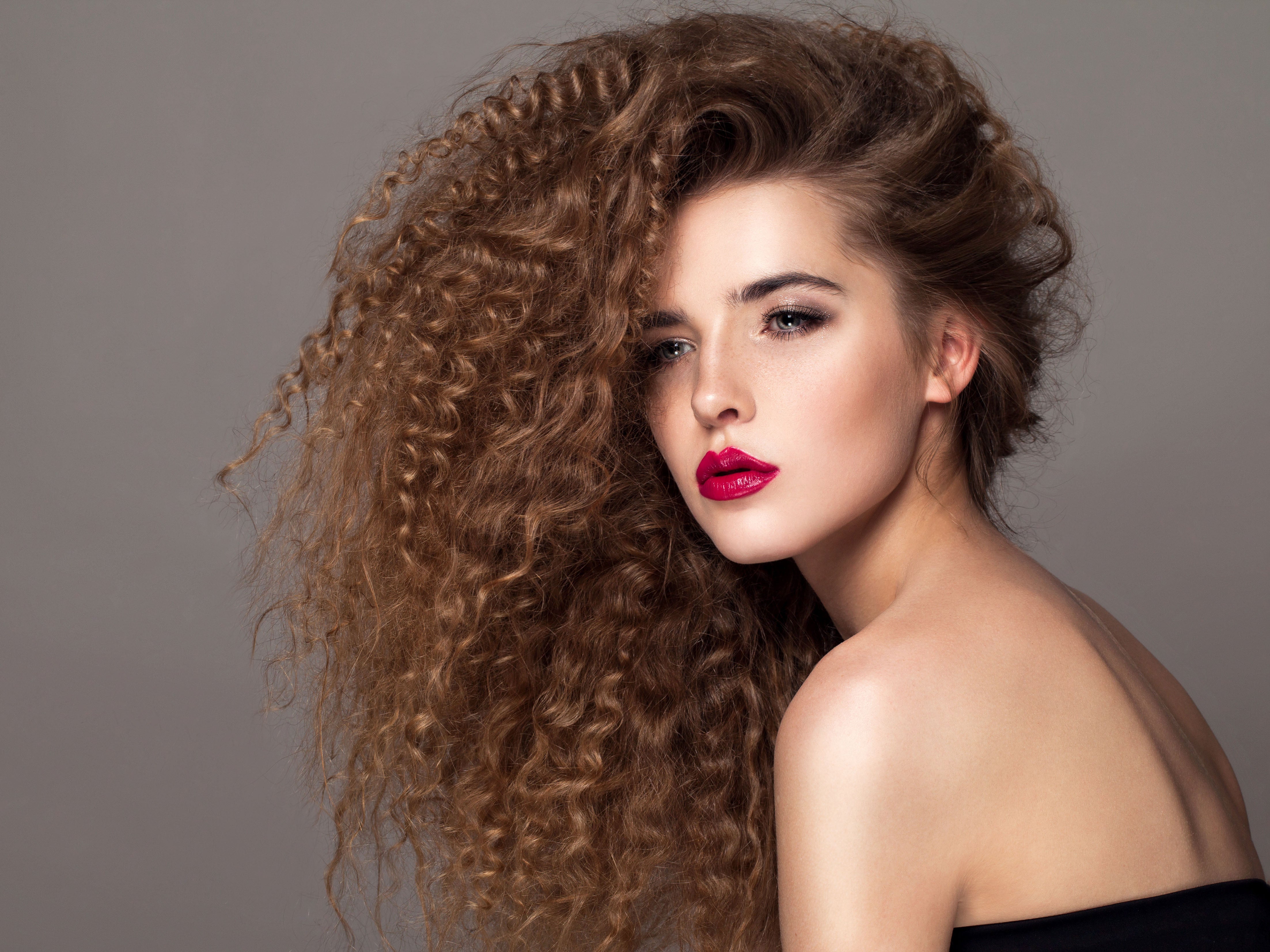 Beautiful young woman with curly and long hair extensions. Permed hair. Beautiful Woman Portrait. Blond Wavy Hair.